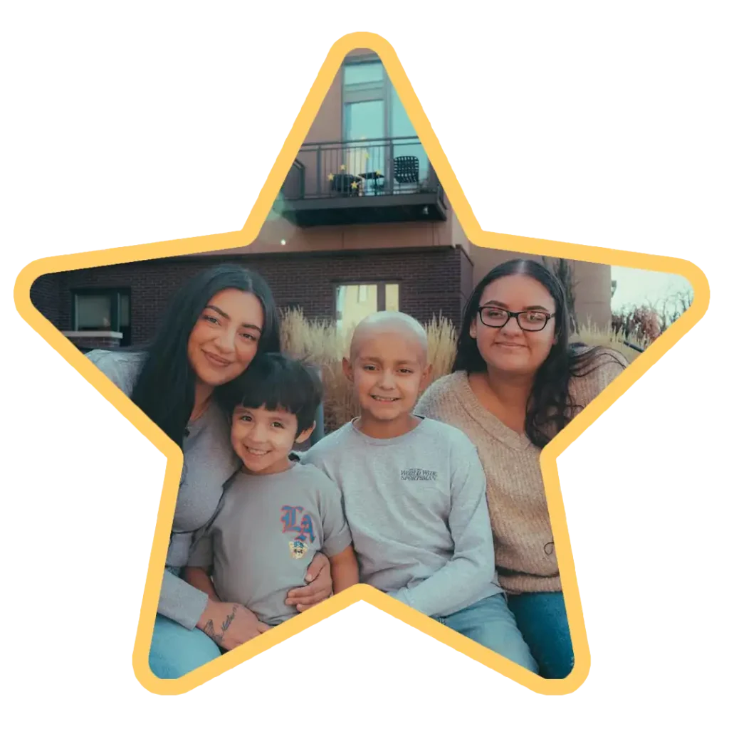 A Brent's Place family sits in the campus courtyard smiling. The photo is in the shape of a star with a yellow border.